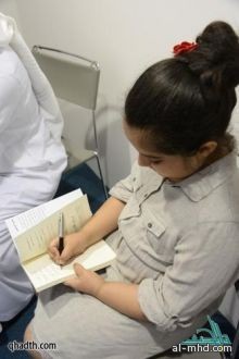 طفلة تضع بصمتها في معرض الكتاب 