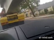 بالفيديو .. سيارة تمر من تحت شاحنتين بالمدينة